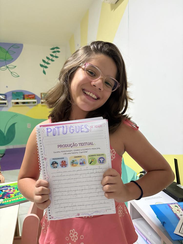 Aluna orgulhosa mostrando sua produção de texto