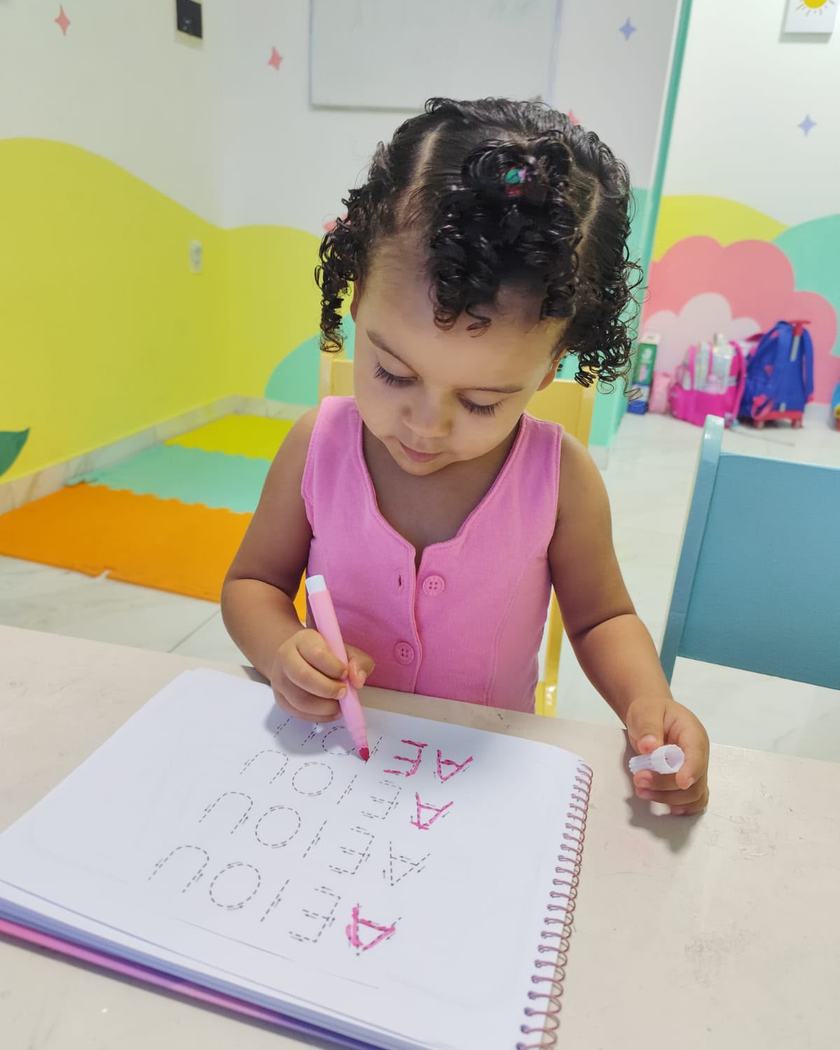 Criança treinando as primeiras letras